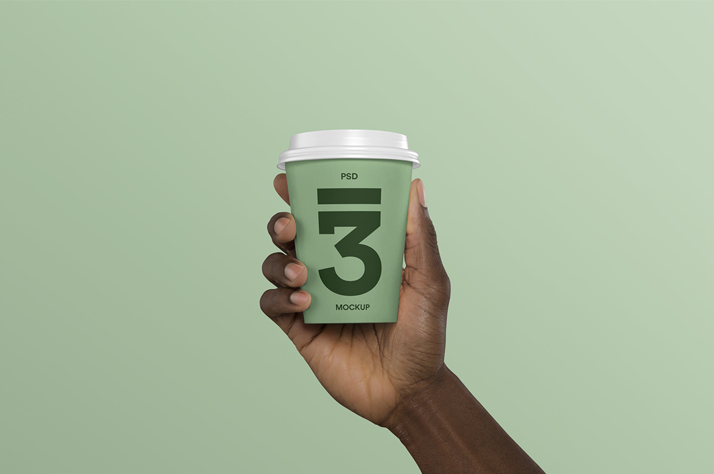 Design mockup of hand holding coffee cup on green background